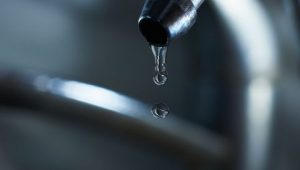Reverse osmosis filter tap closeup with dripping water-drop. studio shot.
